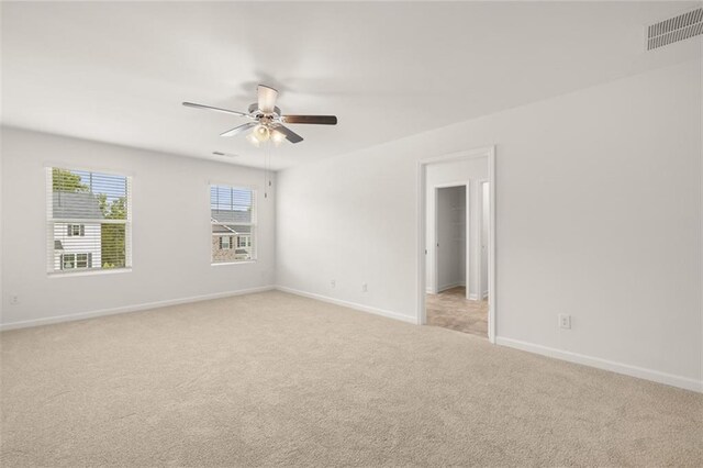 spare room featuring ceiling fan and light colored carpet