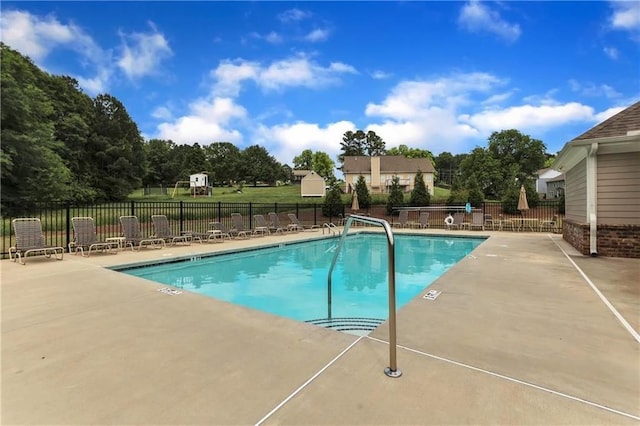 community pool with fence and a patio