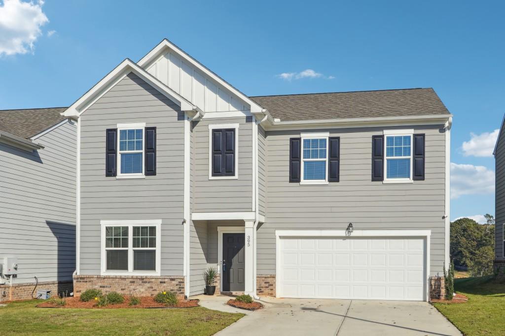 craftsman inspired home featuring a garage and a front yard