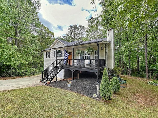 view of front of property featuring covered porch, stairway, a chimney, and a front yard