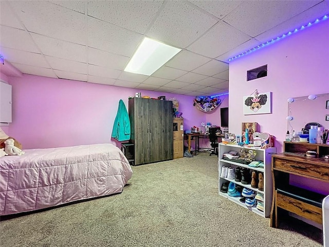 bedroom featuring carpet and a drop ceiling