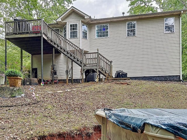 back of property with stairway, a wooden deck, and central air condition unit