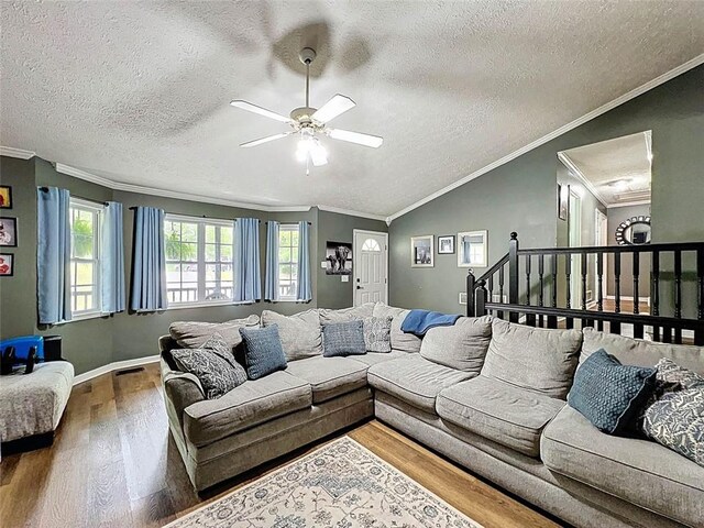 living area with crown molding, ceiling fan, a textured ceiling, and wood finished floors