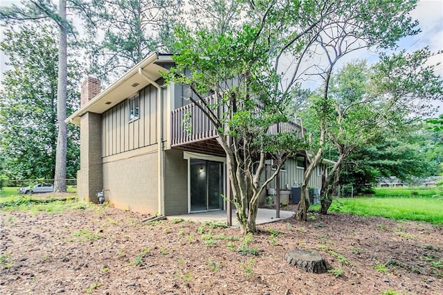 2110 Redbud Ct SW, Marietta, GA 30008 - back of property with board and batten siding, a chimney, a patio, and a deck