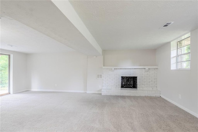 2110 Redbud Ct SW, Marietta, GA 30008 - unfurnished living room with a textured ceiling, a fireplace, healthy amount of natural light, and carpet