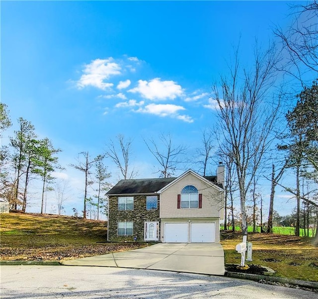 view of front of home with concrete driveway, an attached garage, and a chimney