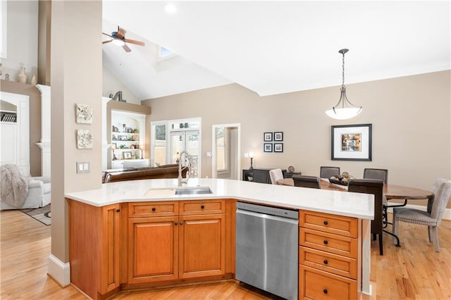 kitchen featuring a sink, light countertops, light wood-style floors, dishwasher, and open floor plan