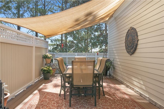 view of patio / terrace with outdoor dining space, a fenced backyard, and a wooden deck