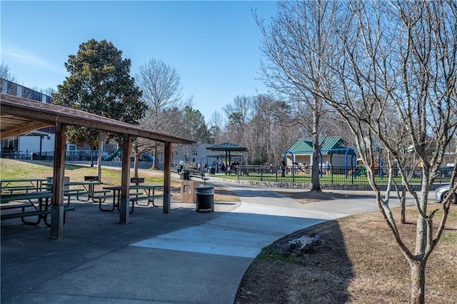 view of community featuring playground community and fence