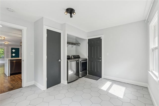 washroom with independent washer and dryer, baseboards, and light tile patterned flooring