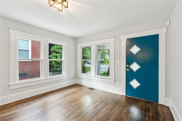 entrance foyer with plenty of natural light, visible vents, wood finished floors, and baseboards