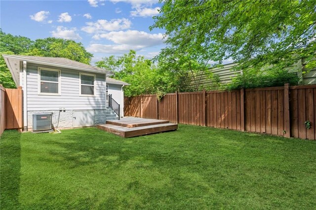 view of yard with central AC unit, a deck, entry steps, and a fenced backyard