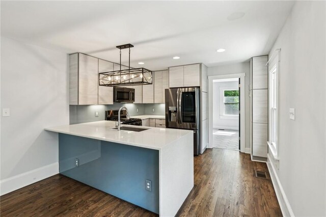 kitchen featuring modern cabinets, visible vents, a peninsula, light countertops, and appliances with stainless steel finishes