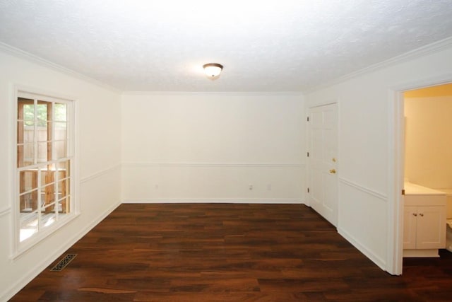 empty room with dark hardwood / wood-style floors and crown molding