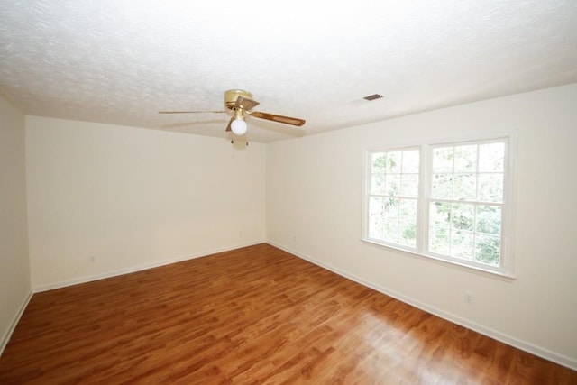 unfurnished room featuring ceiling fan, a textured ceiling, and hardwood / wood-style flooring