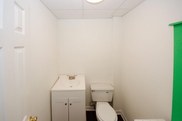 bathroom featuring a paneled ceiling, vanity, and toilet