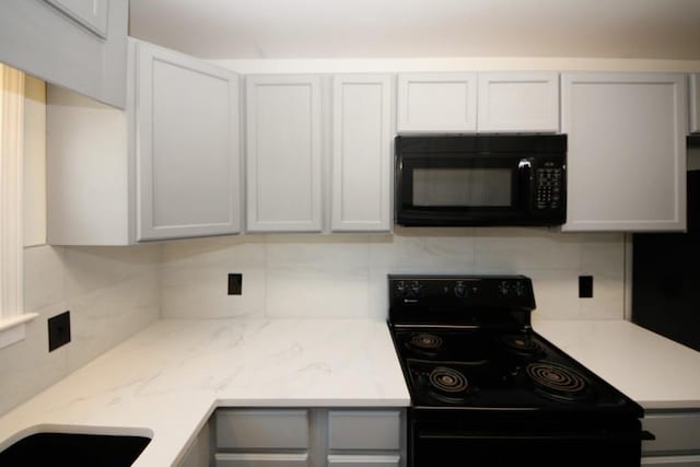 kitchen with tasteful backsplash, sink, and black appliances