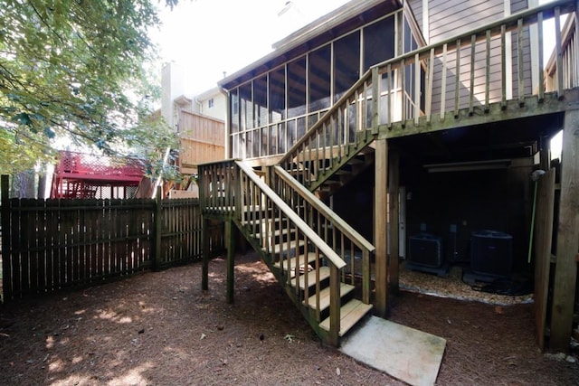 exterior space with a sunroom, central AC unit, and a deck