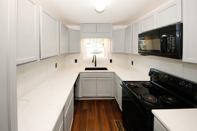 kitchen with backsplash, dark wood-type flooring, sink, and black appliances