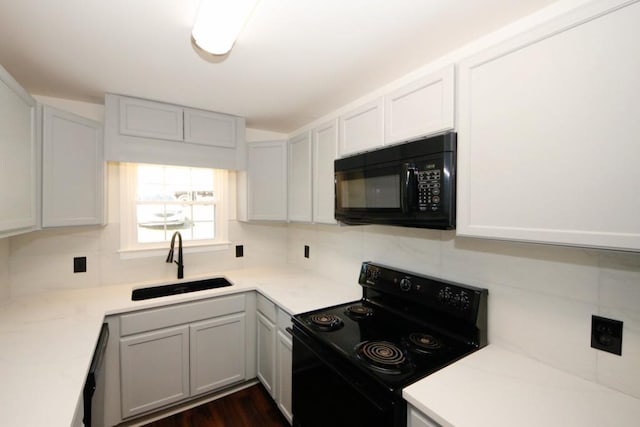 kitchen with decorative backsplash, sink, black appliances, white cabinets, and dark hardwood / wood-style floors