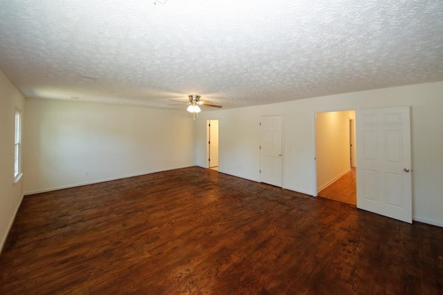 unfurnished room with ceiling fan, a textured ceiling, and dark wood-type flooring