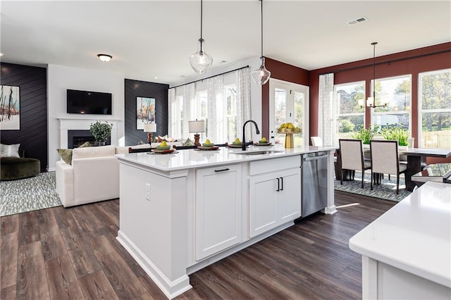 kitchen with pendant lighting, white cabinetry, dishwasher, sink, and an island with sink