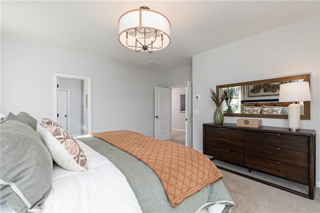 bedroom featuring an inviting chandelier and light colored carpet