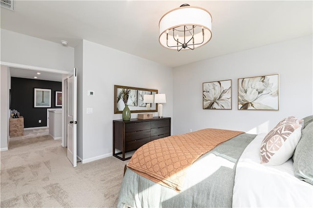 bedroom featuring an inviting chandelier and light colored carpet