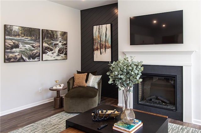 living room featuring hardwood / wood-style flooring and wooden walls