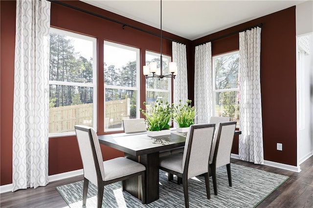 dining room with dark wood-type flooring and an inviting chandelier