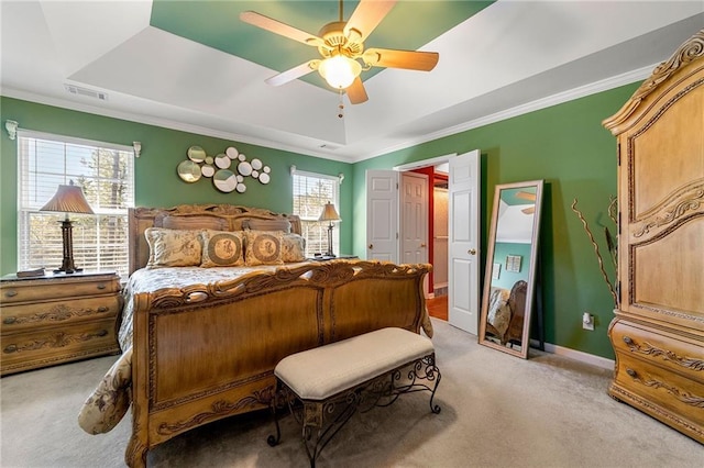 bedroom featuring light carpet, baseboards, visible vents, and a raised ceiling