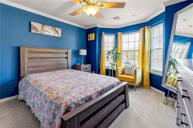 carpeted bedroom with baseboards, visible vents, crown molding, and a ceiling fan