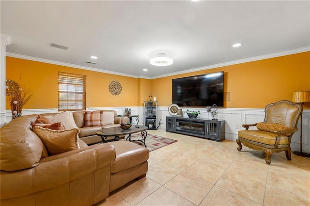 living area featuring wainscoting, tile patterned flooring, ornamental molding, and visible vents