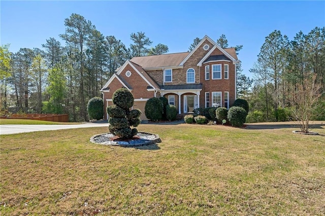 view of front of property with brick siding, concrete driveway, and a front yard