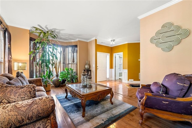 living area with light wood-style flooring and ornamental molding