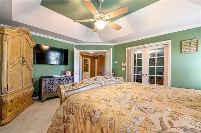 bedroom featuring a tray ceiling, light colored carpet, crown molding, and french doors