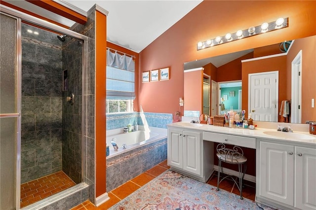 bathroom featuring a bath, lofted ceiling, a stall shower, and double vanity