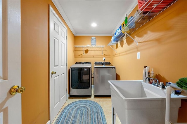 laundry room featuring crown molding, laundry area, a sink, separate washer and dryer, and light tile patterned floors