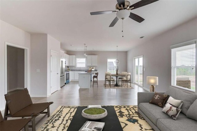 living room featuring ceiling fan and light wood-type flooring