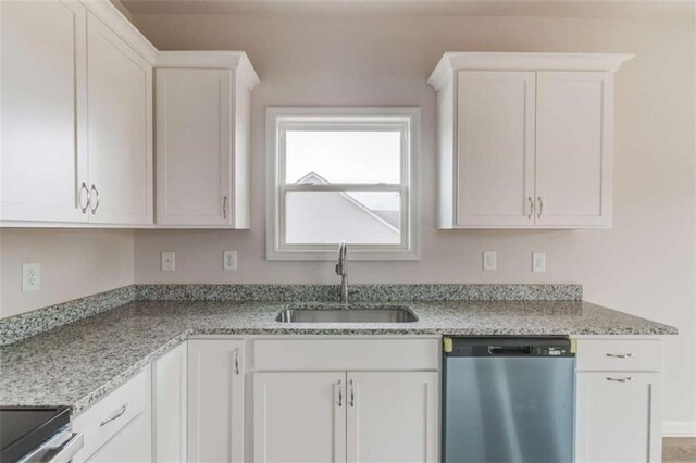 kitchen featuring stainless steel dishwasher, white cabinets, and sink