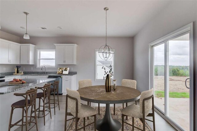 dining space with hardwood / wood-style floors, an inviting chandelier, and sink