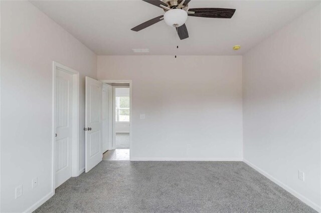 carpeted spare room with ceiling fan