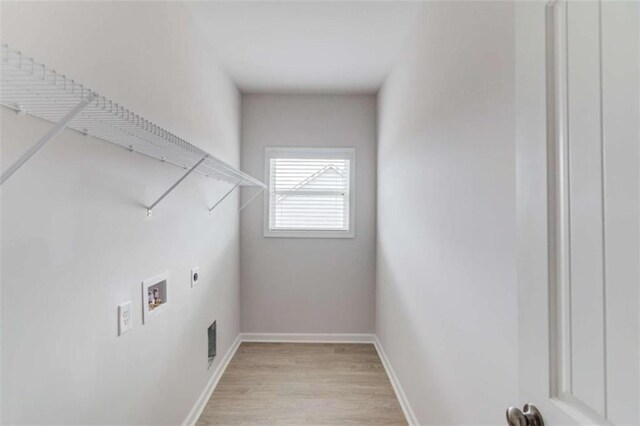 clothes washing area with washer hookup, electric dryer hookup, and light hardwood / wood-style flooring