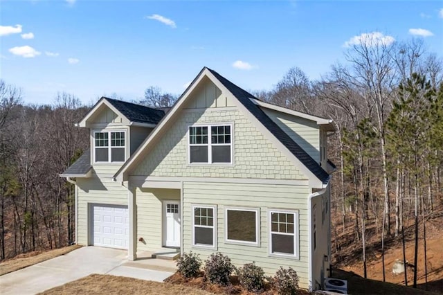 view of front facade featuring a garage, a shingled roof, and concrete driveway