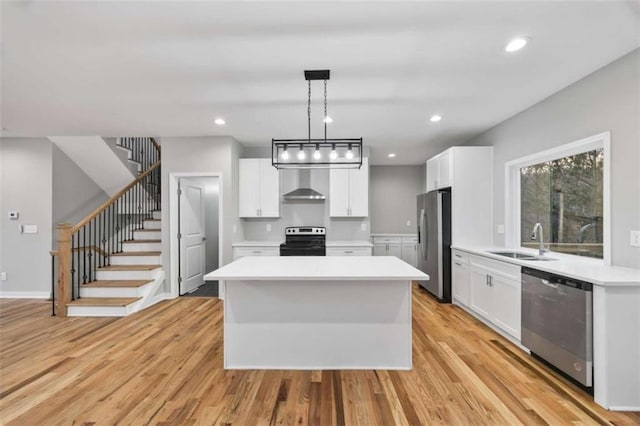 kitchen featuring a kitchen island, stainless steel appliances, a sink, and light countertops