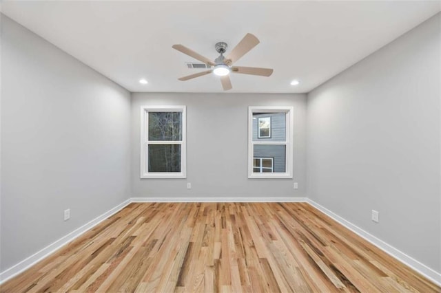 empty room featuring light wood finished floors, baseboards, and recessed lighting