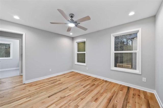 spare room featuring light wood finished floors, baseboards, a ceiling fan, and recessed lighting