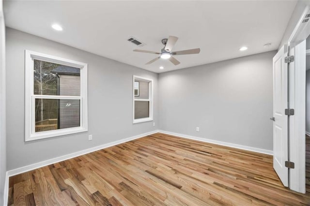 empty room featuring recessed lighting, visible vents, baseboards, and wood finished floors