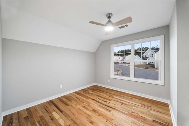 bonus room featuring visible vents, baseboards, vaulted ceiling, and wood finished floors