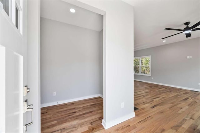 empty room featuring a ceiling fan, recessed lighting, baseboards, and wood finished floors